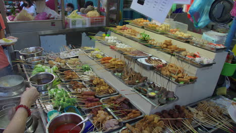Large-Display-of-Meat-Skewers,-People-Buying-and-Collecting-Street-Food,-Night-Market,-Malaysia
