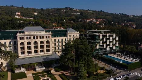 Forward-flying-drone-aerial-view-of-Trieste-Kempinski-palace-hotel,-Italy