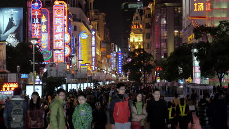 Crowded-with-people-neon-bright-Nanjing-Road-at-night-time,-Shanghai-4K