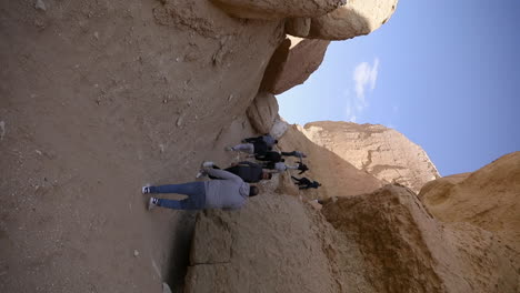 Campers-climbing-the-mountains-in-the-desert-of-Egypt--push-in---vertical-video
