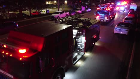 Closeup-aerial-of-firetruck-EMS-flashing-red-blue-lights-at-night,-trucking-pan