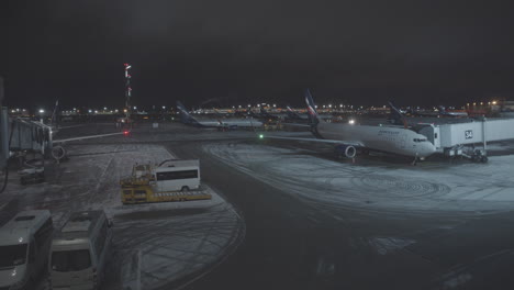 Aeropuerto-De-Moscú-Por-La-Noche-Con-Nieve-En-La-Pista-Y-Servicio-De-Transporte-Al-Aeropuerto---Los-Pasajeros-Entran-Al-Avión---Exterior