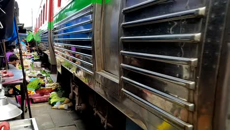 A-train-passes-through-the-market-in-Maeklong,-Thailand