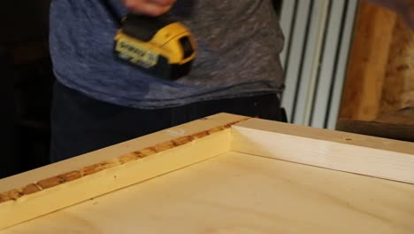 Hammering-wood-and-screwing-together-with-a-yellow-drill