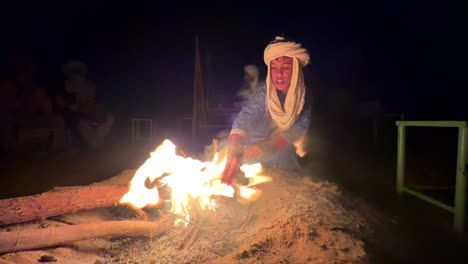 Young-Berber-boy-sat-around-campsite-fire-in-Sahara-Desert-in-Morocco