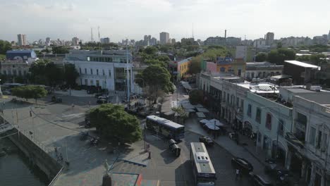 Aerial-Drone-Above-Shore-Street-of-La-Boca-Neighborhood-Buenos-Aires-Argentina-Buses-Driving-during-Clear-Summer-Skyline