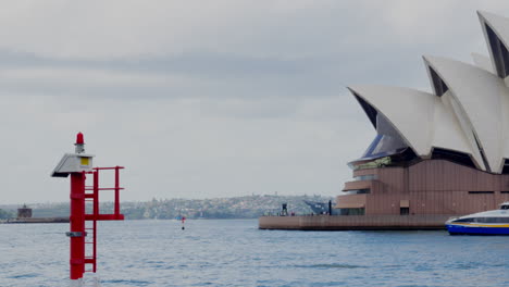 A-small-passenger-ferry-passes-in-front-of-the-Sydney-Opera-House,-Australia
