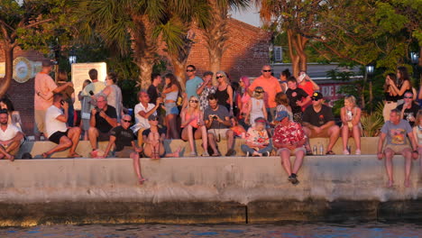 Menschen-Sitzen-Auf-Der-Ufermauer-Des-Mallory-Square-Und-Beobachten-Den-Sonnenuntergang-In-Key-West,-Florida