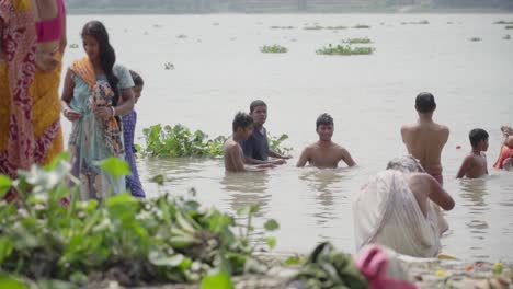 Indian-men-and-women-bathing-and-enjoying-in-river-bank-of-Ganga-in-summer,-Rani-Rashmoni-ghat,-slow-motion