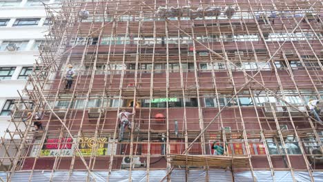 Se-Ve-A-Trabajadores-De-La-Construcción-Trabajando-En-Andamios-De-Bambú-Para-Un-Edificio-De-Apartamentos-Residencial-De-Fachada-De-Mantenimiento