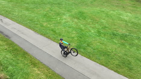 Aerial-View-of-Cyclist-Riding-Sport-Bicycle-on-One-Wheel,-Tracking-Drone-Shot-60fps