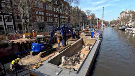 Vista-Estática-De-Barcazas-Y-Trabajos-De-Construcción-En-El-Río-En-La-Soleada-Amsterdam