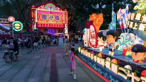 Visitors-and-residents-pose-for-photos-in-front-of-a-lantern-installation-show,-which-symbolizes-prosperity-and-good-fortune,-during-the-Mid-Autumn-Festival,-also-called-Mooncake-Festival
