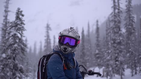 Man-with-helmet-and-a-visor-turning-its-head-in-slow-motion-with-a-winter-landscape-behind