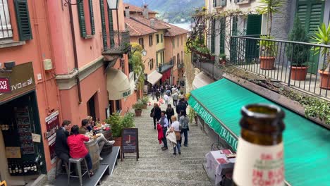 Close-up-of-person-holding-an-italian-calzone-and-beer-bottle-in-traditional-Bellagio-village-in-Como-lake