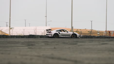 Slow-motion-tracking-shot-of-a-Porsche-GT3-RS-drifting-around-a-race-track