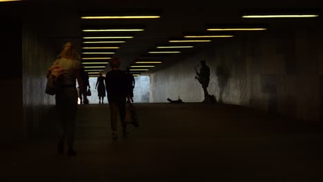 A-street-musician-with-the-saxophone-is-going-to-start-his-performance-in-a-pedestrian-tunnel-with-people-traffic