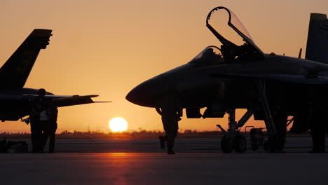 Die-Silhouette-Eines-Marineoffiziers-Rennt-Vor-Einem-Blauen-Engel-Auf-Dem-Rollfeld,-Während-Die-Jets-Für-Eine-Flugshow-Am-Frühen-Morgen-Bei-Sonnenaufgang-In-Key-West-Vorbereitet-Werden