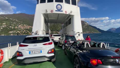 Several-cars-being-transported-on-ferry-boat-between-villages-in-Lake-Como,-Italy