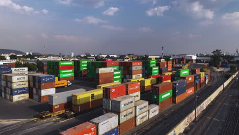 Aerial-view-rising-over-container-boxes-at-a-train-station,-sunny-day-in-Mexico