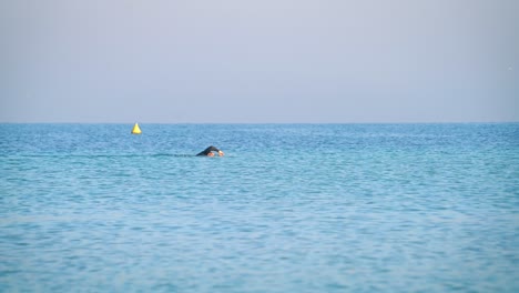 Zeitlupe-Eines-Schwimmers-Im-Blauen-Wasser-Des-Arabischen-Meeres,-Dubai,-Vereinigte-Arabische-Emirate