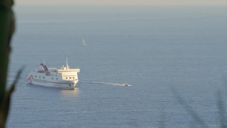 Ferry-Que-Viaja-En-Aguas-Abiertas-En-El-Mar-Mediterráneo-Dirigiéndose-Al-Puerto,-En-Barcelona,-España,-En-Una-Cálida-Tarde-De-Atardecer