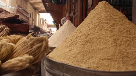Colourful-exotic-spices-and-herbs-on-display-in-Morocco-food-market,-pull-back-shot