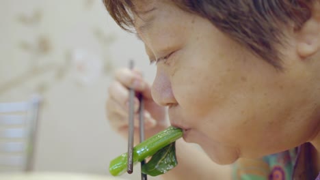 Old-Woman-Eating-A-Delicious-Food-Using-Chopsticks-In-A-Dining-Restaurant-In-China---Close-Up-Shot