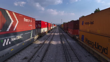 Aerial-view-flying-low-in-middle-of-train-containers,-sunny-evening-in-Mexico
