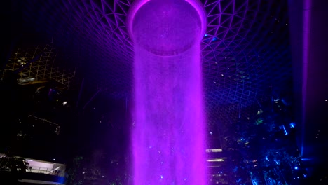 Weitwinkel--Und-Schwenkaufnahme-Des-Violetten-Indoor-Wasserfalls-Am-Flughafen-Singapur