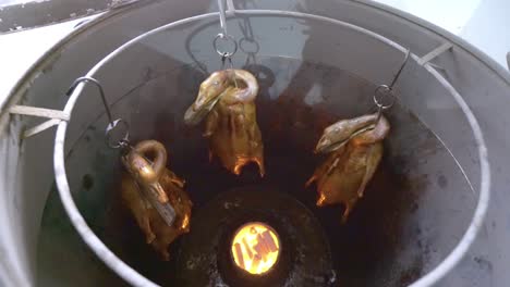 Male-Chef-Opens-The-Lid-Of-Pit-Barrel-Cooker-To-Get-Roasted-Whole-Goose---close-up