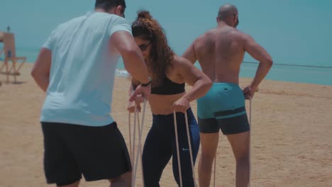 Athletes-walking-using-a-wooden-bar-by-the-beach---Slow-Motion