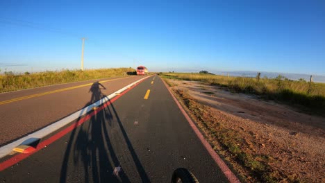 Ciclista-En-Bicicleta-Por-El-Carril-De-Seguridad-Para-Bicicletas-Marcado-En-Una-Carretera-Con-Tráfico-De-Camiones,-Video-Pov