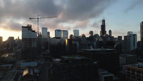 Ascending-aerial-view-of-buildings-in-downtown-Chicago-from-the-Fulton-River-district,-during-sunrise