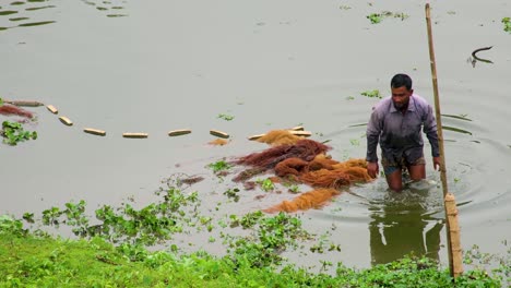 Un-Pescador-Revisa-Sus-Redes-Y-Camina-Por-Las-Aguas-Del-Río-Surma,-Bangladesh.