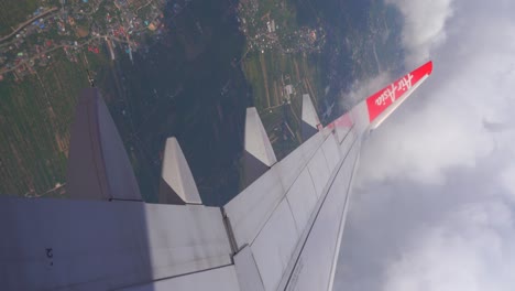 Vertical-view-of-Air-Asia-airplane-climbing-over-beautifl-landscape