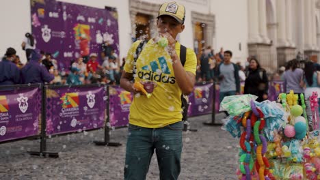 Ein-Mann-Verkauft-Während-Der-Karwoche-In-Antigua,-Guatemala,-Spielzeug-Luftblasenpistolen-Auf-Den-Straßen