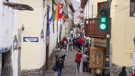 Handheld-shaky-shot-of-people-in-alleyway-intersecting-with-road-in-cusco,-peru