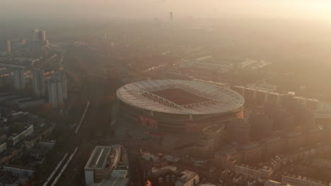 tight-dolly-forward-aerial-shot-towards-Arsenal-football-Stadium-backlit-by-the-sun