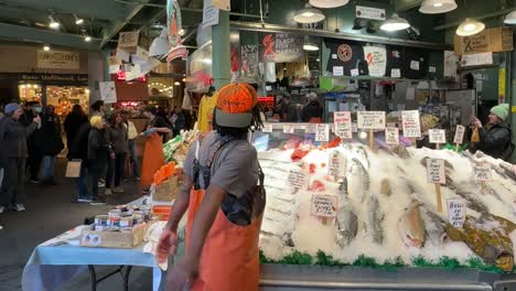 Fischhändler-Unterhält-Menschenmenge-Mit-Berühmtem-Fischwurf-Auf-Dem-Pike-Place-Market-In-Seattle