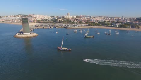 Regatta-on-Tejo-river,-sailing-on-a-calm-waters-with-other-boats,-drone-movement-front-to-back-180?