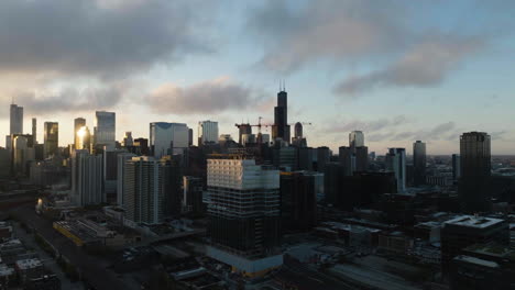 Panoramic-drone-shot-of-a-dramatic-sunrise-with-clouds-above-the-Chicago-skyline-and-Fulton-River-district