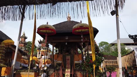 Temple-Decoration-in-Balinese-Hindu-Ceremony,-Colorful-Umbrellas-in-Yellow-Golden-Tones,-Bali-Indonesia