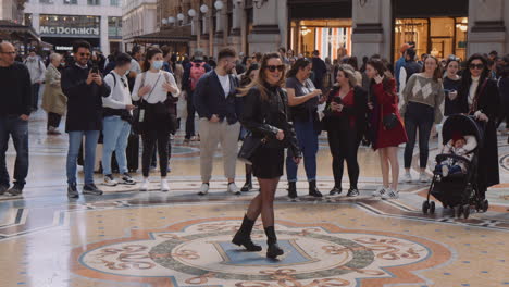 People-Watching-Woman-Spin-Three-Times-On-The-Turin-Bull-Mosaic-Floor-Inside-The-Galleria-Vittorio-Emanuele-II-In-Milan,-Italy