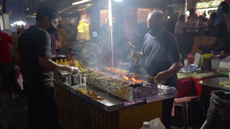 Satay-vendors-fanning-the-flames-of-satay-at-Lau-Pa-Sat-Singapore