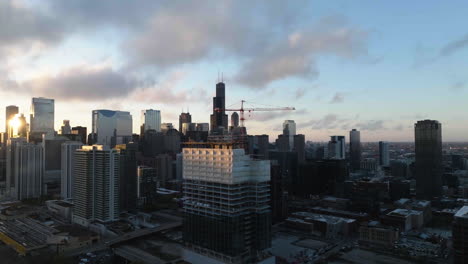 Aerial-view-away-from-the-360-North-Green-Street-construction-site-in-West-Loop,-Chicago,-during-sunset---pull-back,-drone-shot
