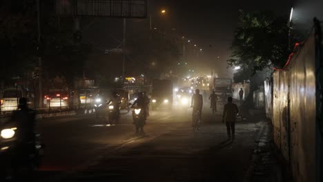 Starker-Verkehr-In-Der-Nacht-In-Neu-Delhi,-Indien,-Vorbeifahrende-Fahrräder