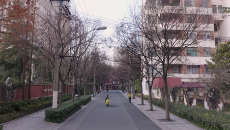 Static-Drone-Shot-in-Shanghai-Showing-Scooter-Drive-by-on-Empty-Street-Before-Covid-19-Lockdown-in-Winter