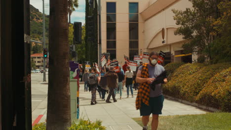 Street-view-of-the-Writers-Guild-of-America-on-strike-at-Warner-Brothers-Studios-crowded-by-Gate-3-on-Olive-Avenue-in-Burbank,-California
