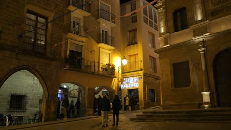 Menschen-Besuchen-Und-Genießen-Die-Nacht-In-Der-Bar-Am-Hauptplatz-Der-Historischen-Stadt-In-Alcañiz,-Spanien